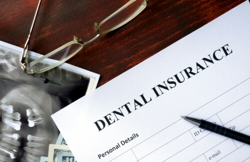 Dental insurance paperwork on a wood desk