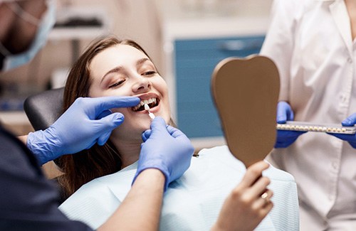 A dentist assessing a woman for cosmetic dentistry
