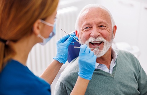 Man smiles at dental hygienist