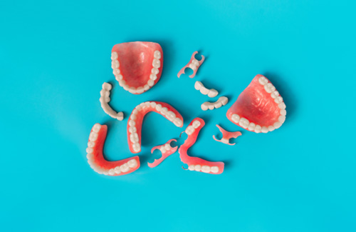 Various types of dentures against a blue background
