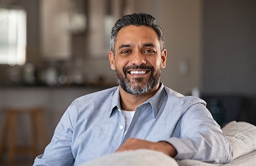 Man smiling while sitting in couch at home