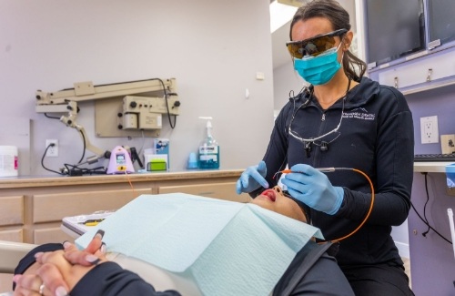 Dental team member holding laser device