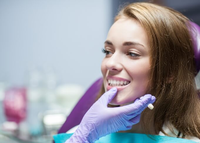 Young woman smiling at her dentist after treatment with restorative dentistry in Orem