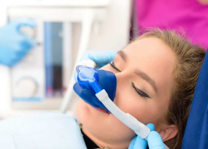 Young woman relaxing in dental chair with nose mask for nitrous oxide sedation dentistry