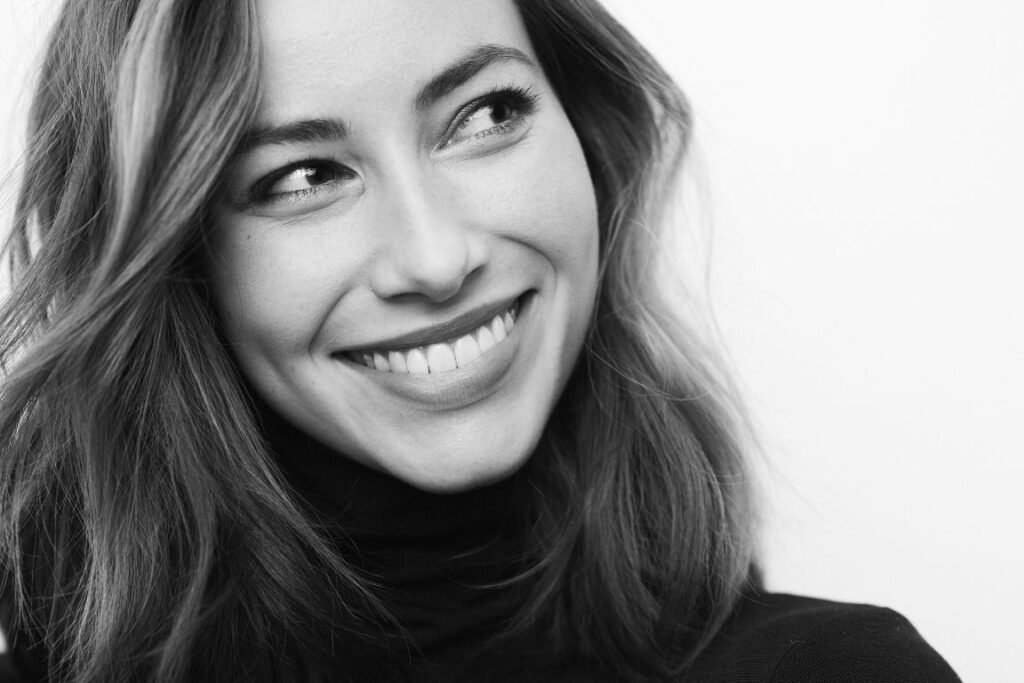 A black and white photo of a woman smiling