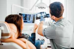 Dentist showing patient X-ray.